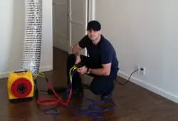Man using air duct inspection equipment indoors