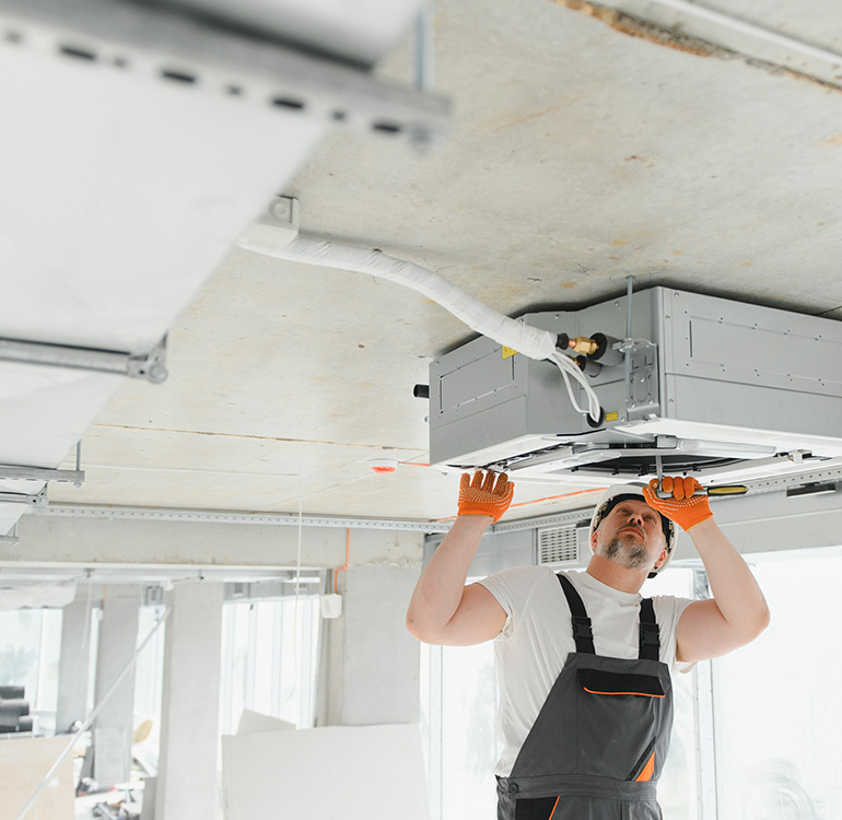 HVAC technician installing ceiling unit