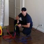 Man using air duct inspection equipment indoors